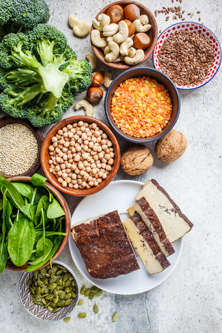 Vegan sources of protein background. Tofu, chickpeas, lentils, nuts, spinach and broccoli - vegetable proteins.